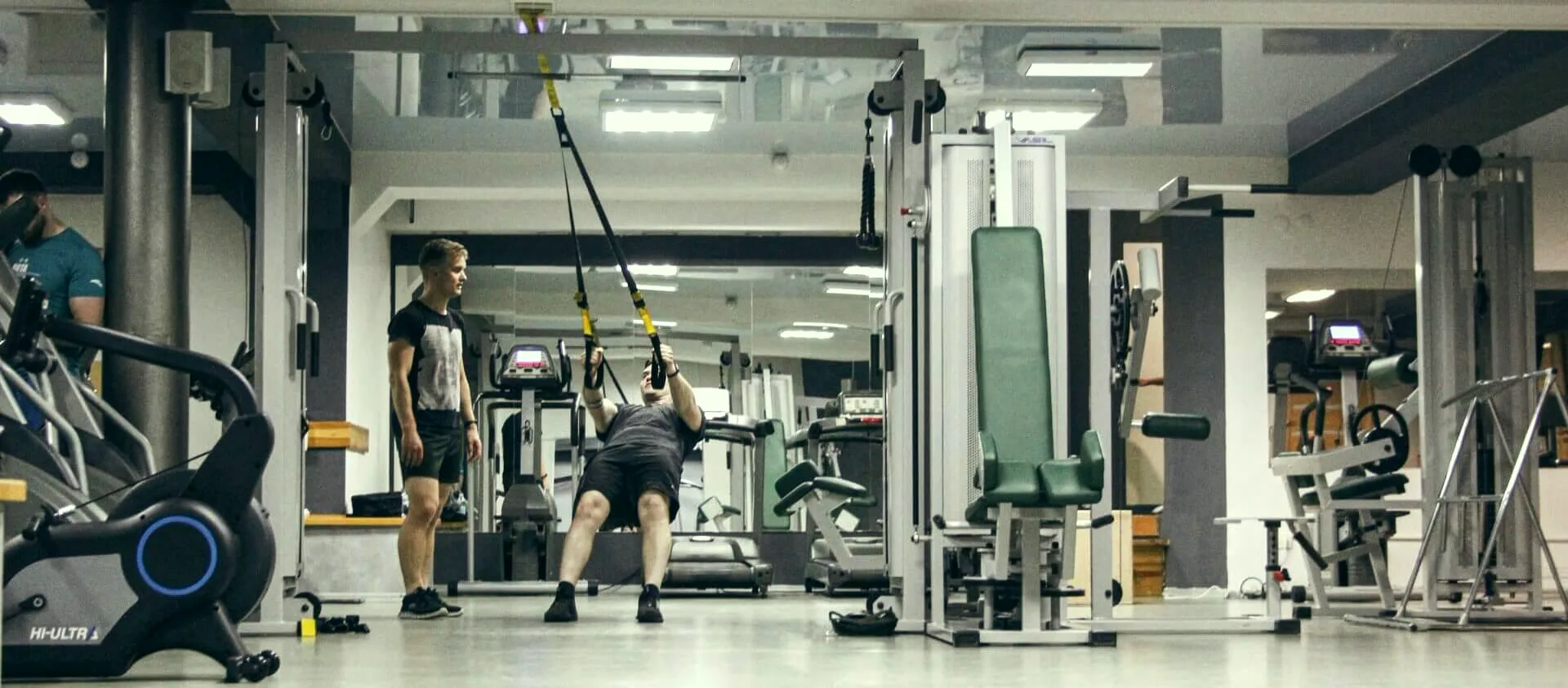 Тренер FitMe супроводжує клієнта на TRX — робочий момент персонального тренування